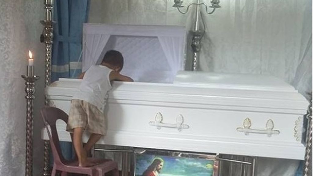 La foto conmovedora del nene que no quiere separarse del ataúd de su madre | Internacionales