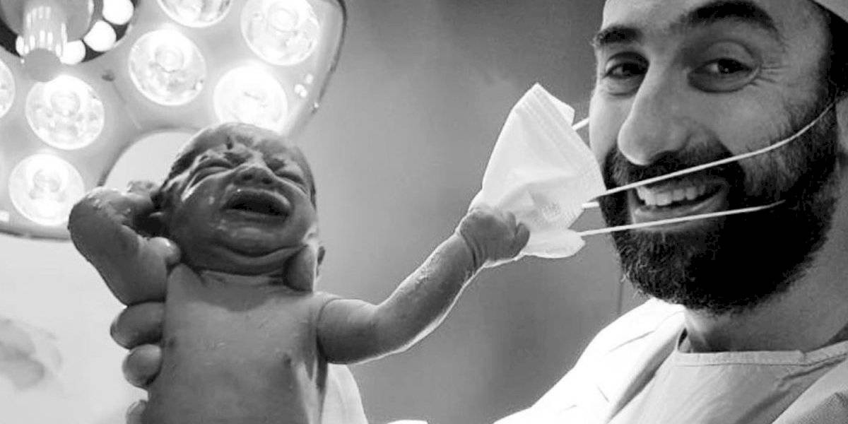 La foto de la esperanza: el bebé recién nacido que le quita el barbijo al médico | Internacionales