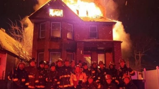 Polémica por una foto grupal de bomberos con una casa en llamas de fondo
