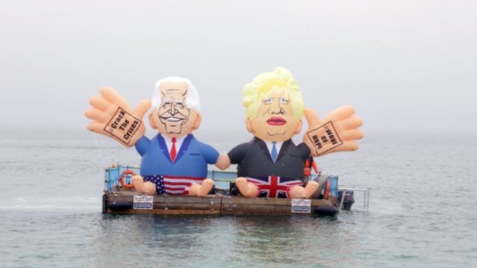 Dos muñecos inflables de Johnson y Biden flotan en una balsa en las costas de Cornualles