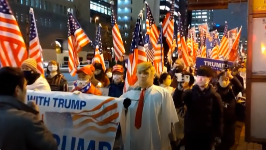 Las marchas a favor de Trump se replicaron en Japón con máscara y banderas de EE.UU.