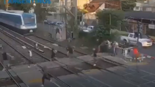 Increíble pelea de jóvenes a centímetros del paso de un tren
