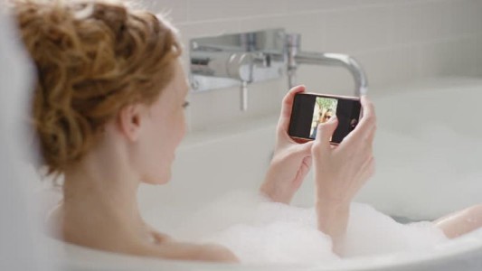 Murió una chica de 22 años electrocutada en la bañera: estaba viendo TV en el celular mientras se cargaba