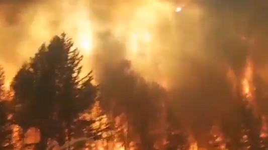 El momento en que los bomberos deben huir ante el descontrol de las llamas