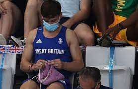 El campeón británico Daley teje en las tribunas durante una final de saltos