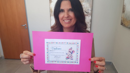 Con un diploma una jueza cordobesa explicó la sentencia de adopción a dos hermanas