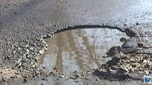 Cansados de esperar una respuesta, docentes reparan baches en la puerta de la escuela